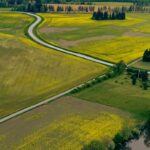 Explore the picturesque aerial landscape of Porvoo, Finland with lush fields and winding roads.